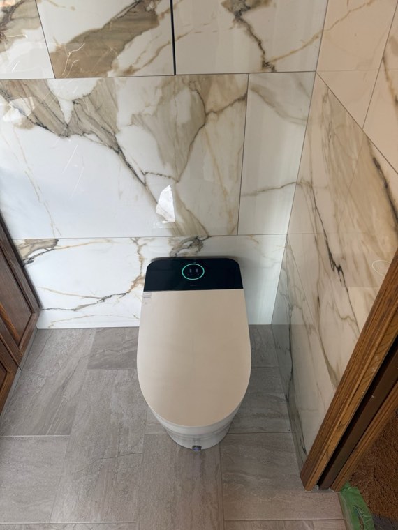 Smart toilet installed in a marble-tiled bathroom