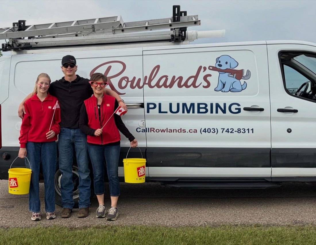 The Rowland's Plumbing family in front of the company van